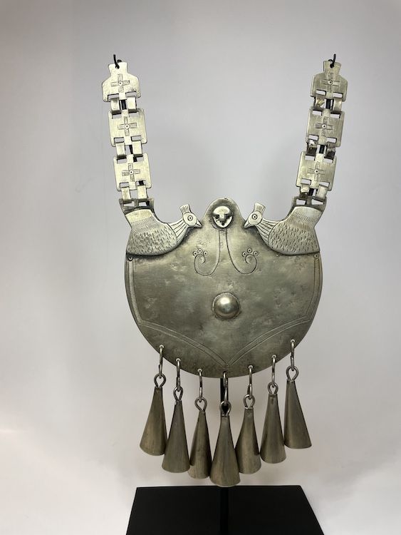 Excepcional collarón mapuche masculino en alpaca, con aves enfrentadas, rostro central, eslabones decorados con cruces y siete campánulas colgantes.