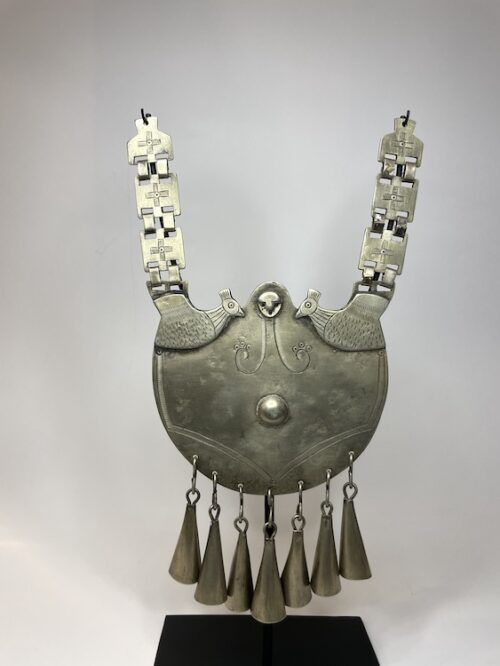 Excepcional collarón mapuche masculino en alpaca, con aves enfrentadas, rostro central, eslabones decorados con cruces y siete campánulas colgantes.
