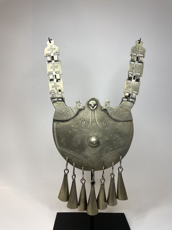 Excepcional collarón mapuche masculino en alpaca, con aves enfrentadas, rostro central, eslabones decorados con cruces y siete campánulas colgantes.